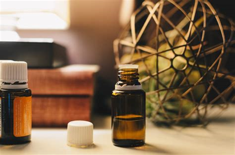 Essential oil bottle sitting on a rustic table next to some books