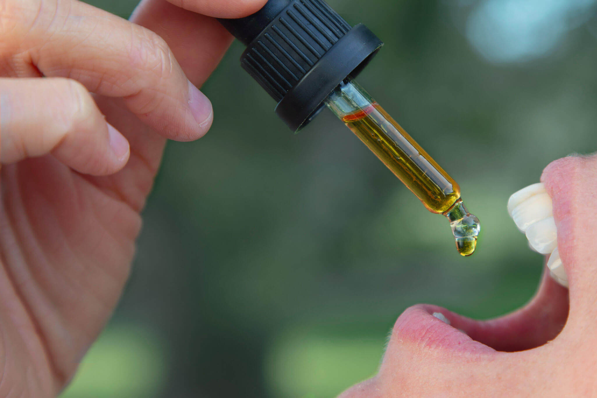 Person dropping tincture in their mouth