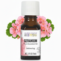 Aura Cacia Geranium essential oil with geranium flowers behind it