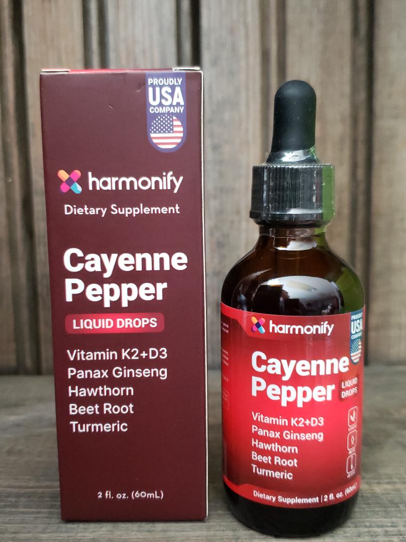 Cayenne Pepper liquid drops with packaging on a wooden surface