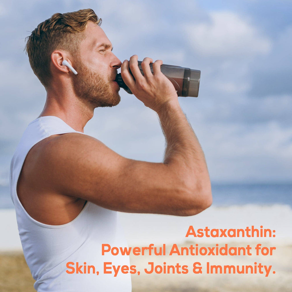 Man drinking from a water bottle with text about astaxanthin benefits on a beach.