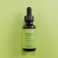 Bottle of HempLucid 10:1 water soluble drops on a green background