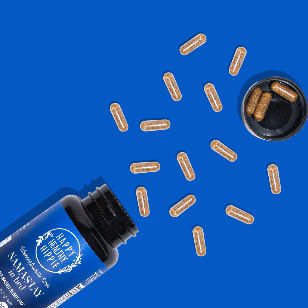 Blue bottle of Happy Hippie Namastay with loose capsules on a blue background