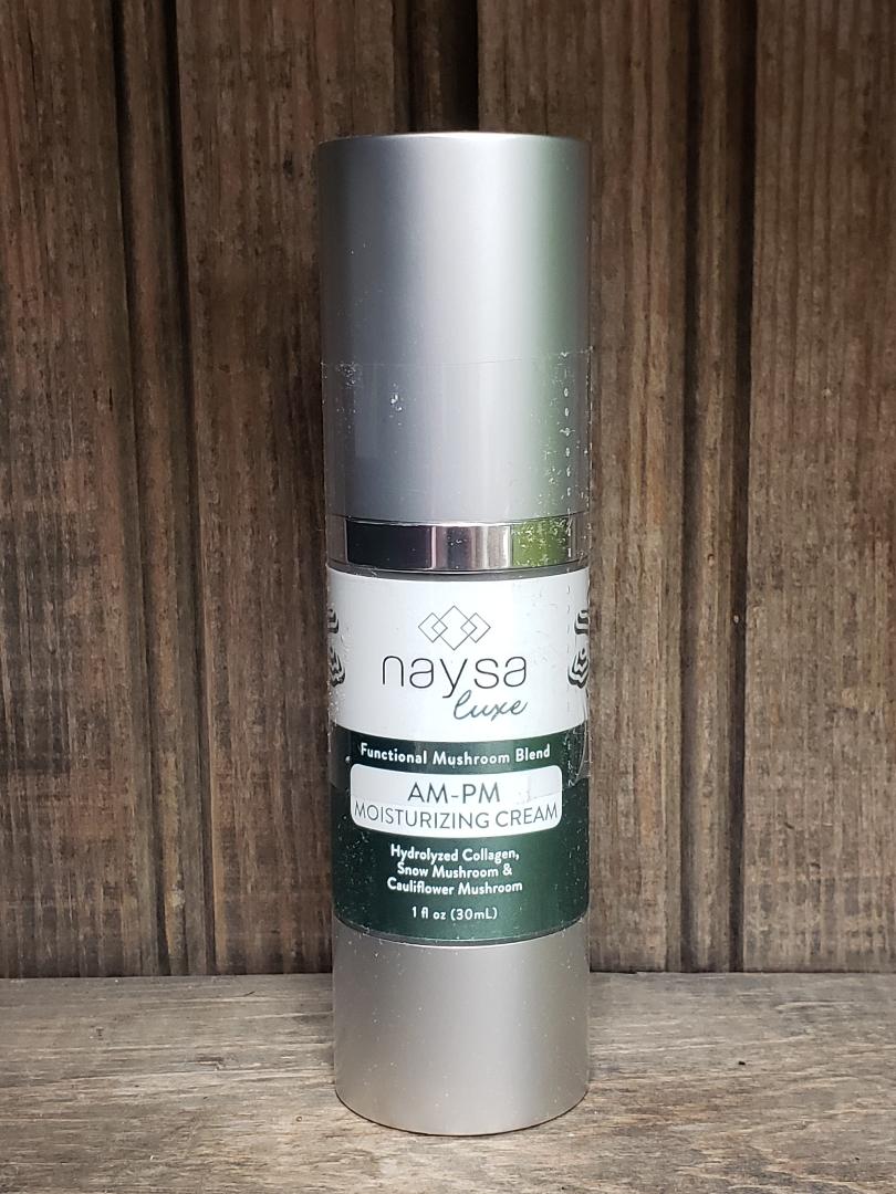 A pump bottle of Naysa Luxe AM/PM Moisturizing Cream placed against a wooden background.