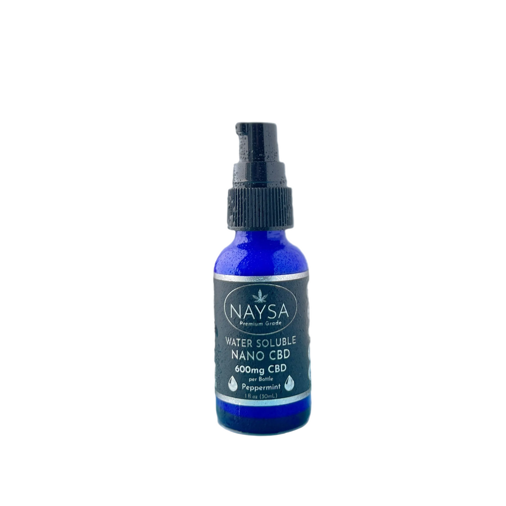 Naysa CBD spray bottle on a reflective surface with a blurred plant in the background