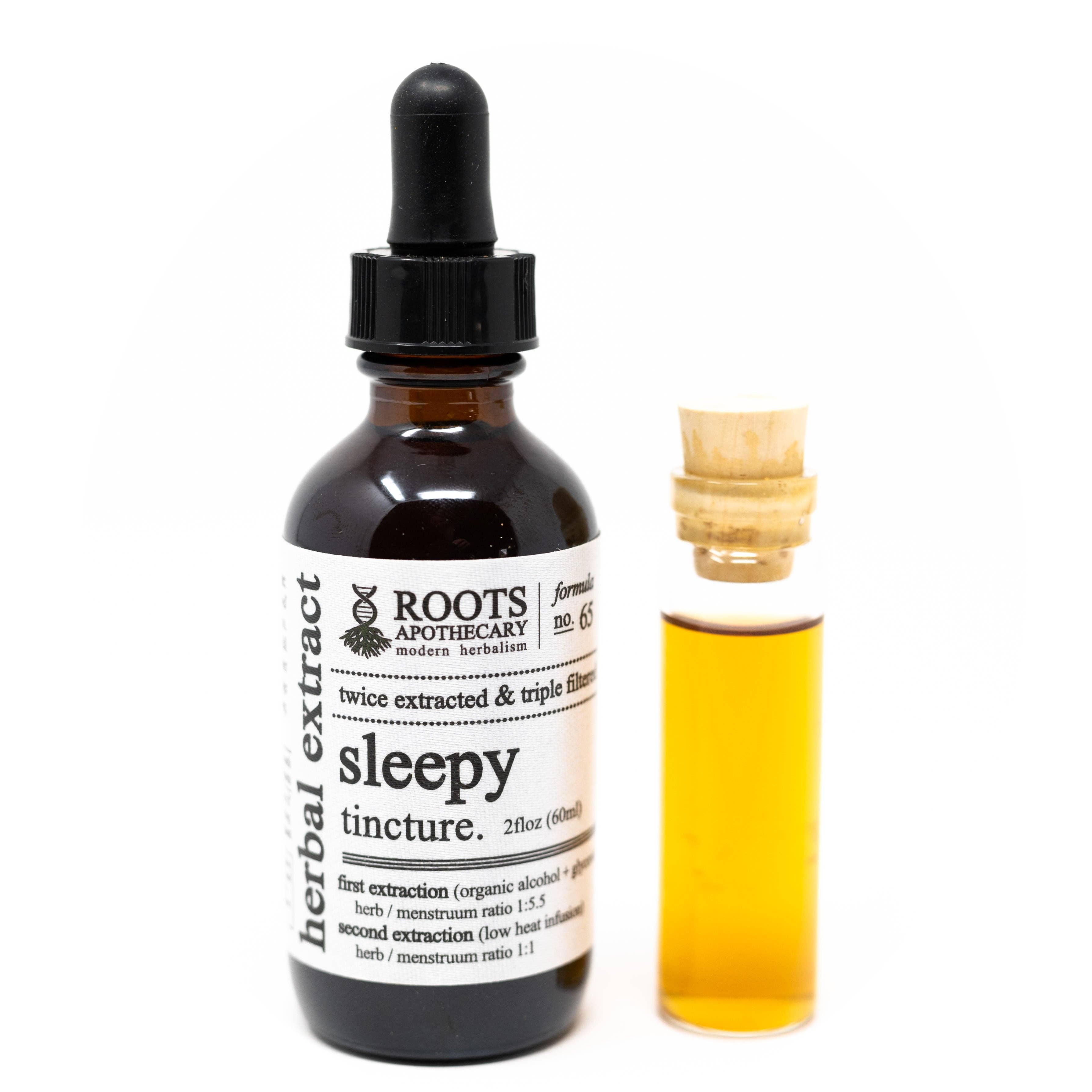 Bottle of Roots Apothecary sleepy tincture with dropper and small vial of liquid on a white background