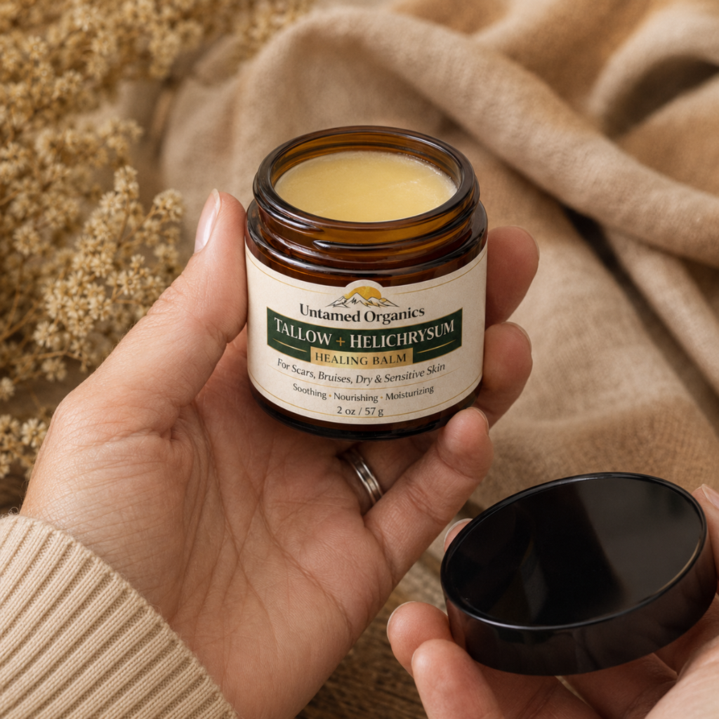 Hand holding a jar of 'Untamed Organics' balm with a beige background